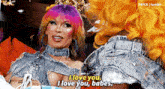 two drag queens are sitting next to each other and one says i love you i love you babes