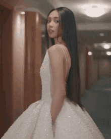 a woman is wearing a white dress with pearls on it