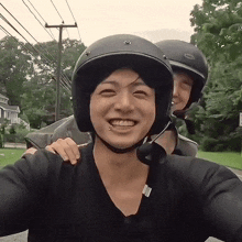 a man wearing a bell helmet smiles with another man