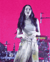 a woman in a crop top and khaki pants is standing on a stage