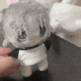 a stuffed animal with gray hair and a white shirt