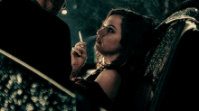 a woman is smoking a cigarette in a car and smiling