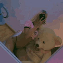 a woman is taking a picture of herself with a teddy bear