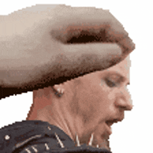 a hand is holding a man 's head in a pixelated image .