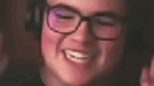a close up of a person wearing glasses smiling .