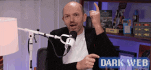 a man sitting in front of a microphone with the words dark web on the bottom