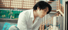 a man in a white shirt is looking down