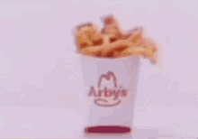a blurred image of a person sitting on a bed with a candle in the background .