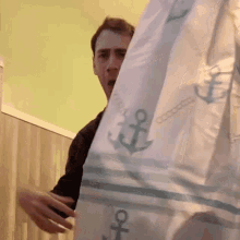a man holds a shower curtain with anchors on it