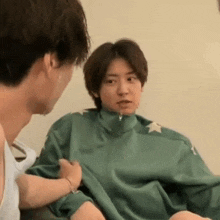 a man is putting a green jacket on a woman 's chest .