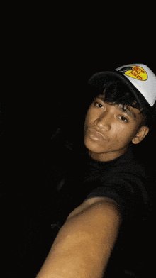 a young man wearing a bass pro shops hat