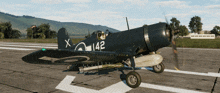 a black plane with the number 142 on the tail