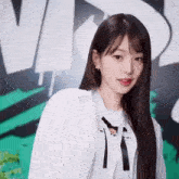 a young woman with long hair is wearing a white shirt with the letter t on it .