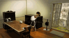 a room with a wooden table and chairs and a skeleton on the floor