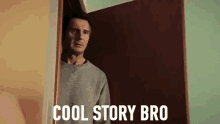 a man is standing in a doorway with the words `` cool story bro '' written on the door .