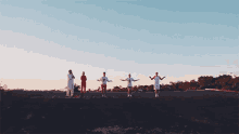 a group of people are jumping in the air while standing on top of a dirt field .