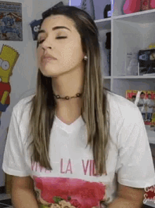 a woman wearing a white t-shirt that says viva la vida on it