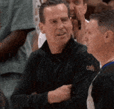 a man wearing a black jacket with the word cavs on the back