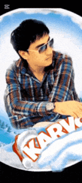 a man wearing sunglasses and a watch is sitting in front of a karv candy bar