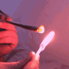 a person is holding a lighter with a pink flame on it