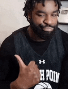a man with a beard is wearing a jersey that says h point and is giving a thumbs up
