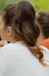 a close up of a woman 's back with a ponytail .