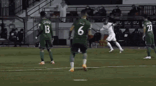a group of soccer players are on a field and one has the number 6 on his jersey