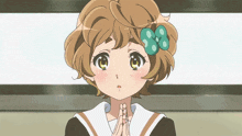a girl with brown hair and a green bow on her hair