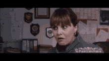 a woman is making a surprised face in a police station .