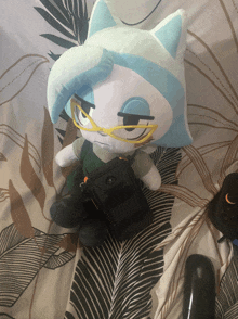 a stuffed animal with glasses is sitting on a bed next to a speaker