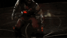 a man in a video game is holding a knife with a red light coming out of it .