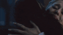 a woman with tears running down her face is being held by a man