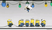 a group of minions standing next to each other under christmas lights