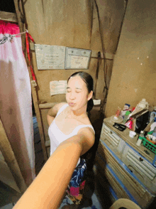 a woman taking a picture of herself in a room with papers on the wall