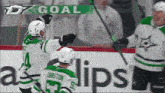 hockey players celebrate a goal with a banner that says d7 goal