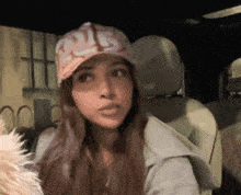 a woman wearing a hat with the letter s on it is sitting in a car