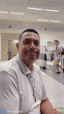 a man in a white shirt is smiling in a momento app