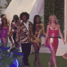 a group of people are walking down a runway and holding hands .