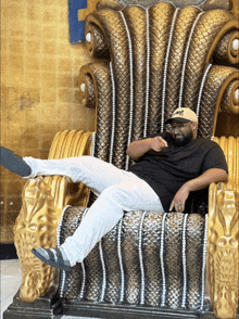 a man sitting on a throne with his leg up and a hat that says ' miami ' on it