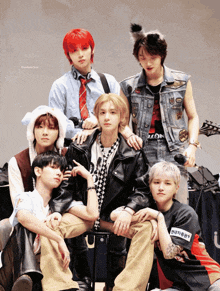 a group of young men are posing for a picture and one of them has a tattoo on his arm that says ' eation '