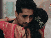 a man is hugging a woman who is wearing a red dress