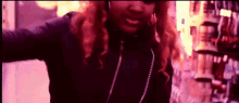 a woman with long red hair is wearing a black jacket and earrings