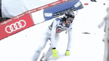 a skier is going down a snowy slope with an audi sign in the background