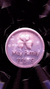 a purple coin with a clover and the words mey family 111519
