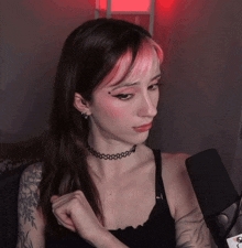 a woman wearing a choker and earrings looks at the camera