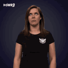 a woman wearing a black shirt with a moose on it looks up at something