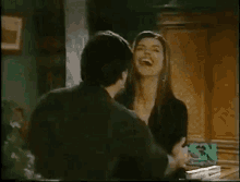 a man and a woman are standing next to each other in a room with sn written on the screen