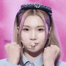 a woman wearing a headband with rhinestones on it is making a funny face