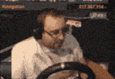 a man wearing headphones is driving a car with a navigation screen in the background