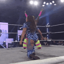 a woman in a wrestling ring with the word impacto on the wall behind her